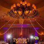 A huge chandelier and SAYDEE marquee letters in the stage