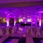 A banquet hall in Las Vegas with purple lighting offers uplight rentals.