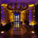 A hallway decorated with gold and white balloons, featuring Uplight Rentals in Las Vegas.