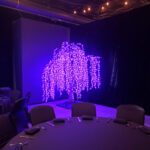 A table with a twinkling purple tree in the middle of it.