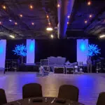 An indoor event setup with blue lights on stage