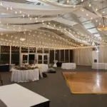 An indoor event with white, round tables 