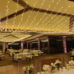 A banquet room adorned with beautiful bistro lighting.