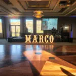 A dance floor with marquee letter rentals that spells out "Marco" on it.