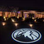 The Minneapolis Timberwolves logo is projected onto a driveway at night using uplight rentals in Las Vegas.