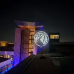 A building with a logo on top of it at night, featuring Uplight Rentals in Las Vegas.