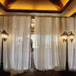 A room with a white curtain and two lamps, available for Lamp Post Rental Las Vegas.