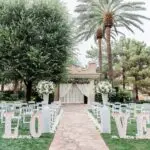 An outdoor wedding ceremony setup with LOVE marquee letters