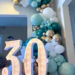 An elegant 30th birthday balloon arch adorned with gold and teal balloons, perfect for any celebration.