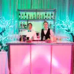 Two people standing behind the counter of the bar area