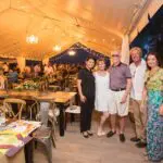 Five people standing near the tables