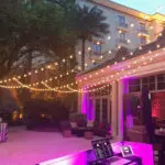 An outdoor event setup with hanging lights and purple lights