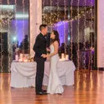 The groom wearing a black suit and the bride wearing a mermaid wedding dress