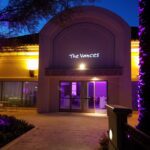 A facility with LED logo name on top of their entrance door and has purple lights 