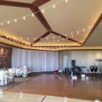 An enchanting wedding reception set up with string lights hanging from the ceiling, creating a picturesque ambiance.