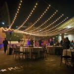 A wedding reception at Springs Preserve Las Vegas with string lights hanging over tables and chairs.