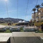 An outdoor event set up with white tables and chairs at Event Lighting at Reflection Bay Las Vegas.