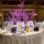 A white table with a pink tree on it, beautifully illuminated for an event at the Las Vegas strip.