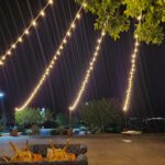 A grassy area featuring a couch illuminated by string lights creating a cozy atmosphere perfect for Event Lighting at Revere Las Vegas.