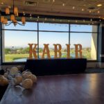 Revere Las Vegas offers event lighting on their dance floor, featuring balloons and the word kabir.