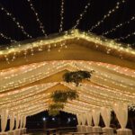 A wedding under a tent covered in fairy lights at different venues.