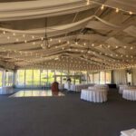 A large tent at Hilton Lake Las Vegas adorned with elegant white tablecloths and mesmerizing string lights creates the perfect ambiance for your event.