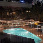 A pool at night adorned with string lights, creating a magical ambiance reminiscent of event lighting at the Las Vegas strip.