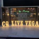 A marquee sign that says co live vegas in front of a building.