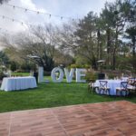 An enchanting wedding reception at JW Marriott Las Vegas, featuring elegant event lighting, a beautifully crafted wooden dance floor, and a breathtaking love sign as the focal point.