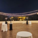 An elegant wedding reception set up at JW Marriott Las Vegas, featuring white tables adorned with string lights, creating a magical and enchanting atmosphere.