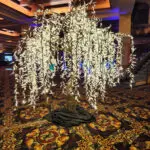 A LED lighted tree with white lights in the middle of a casino.