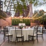 A table setup with white table cover and chairs