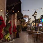 A sidewalk with red umbrellas and event lighting at the Las Vegas strip.