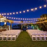 A wedding ceremony set up with white chairs and string lights at CiliLake Las Vegas, featuring event lighting.