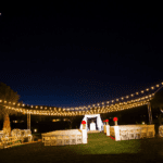 A wedding ceremony set up in a grassy area at night with event lighting at Red Rock Country Club Las Vegas.