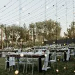 An outdoor reception set up with clear tables and string lights at Lotus House Las Vegas.