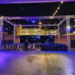 A SPECIALTY stage set up in a parking lot at night with OTHER Event Lighting.