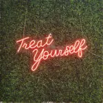 LED Flex Neon Sign Rentals Las Vegas: A neon sign that says treat yourself on a green wall.