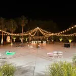 An outdoor wedding at Lotus House Las Vegas featuring string lights and palm trees.